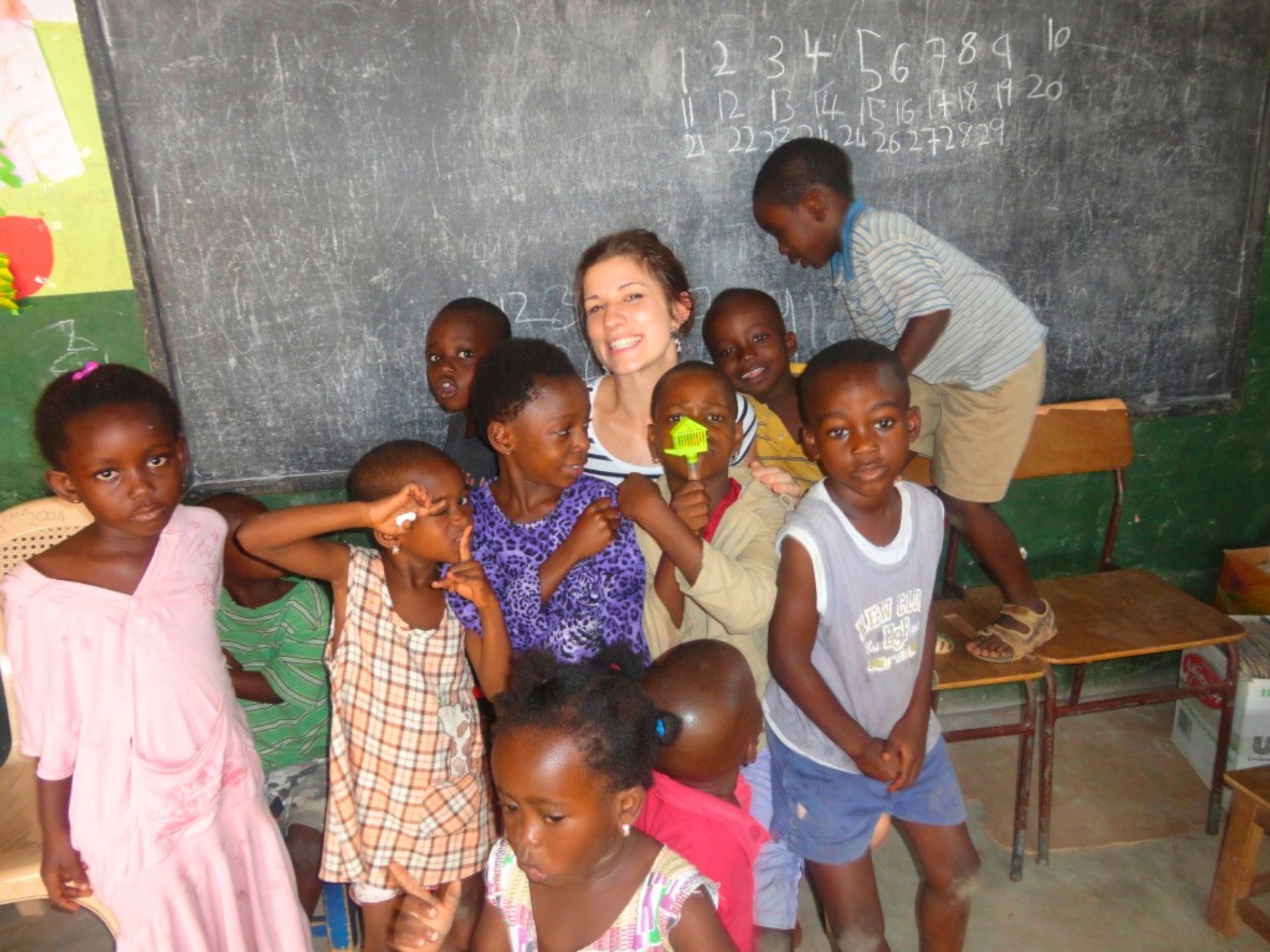 Voluntärin zusammen mit Kindern einer Schule in Ghana